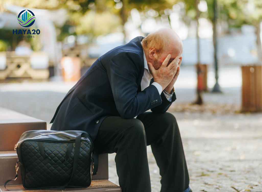 Retired man sitting with his head in his hands, illustrating the financial stress that can result from dropping life insurance too soon.