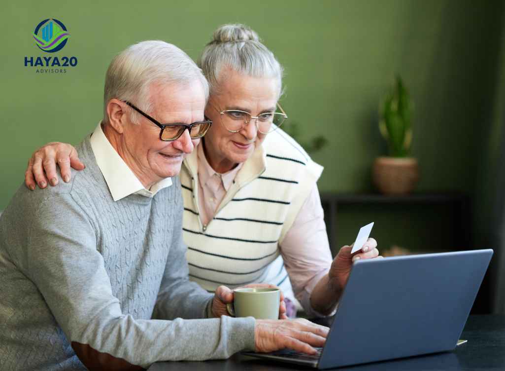 Elderly couple reviewing financial information together on a laptop, representing retirement planning and the shift from earning to protecting wealth.
