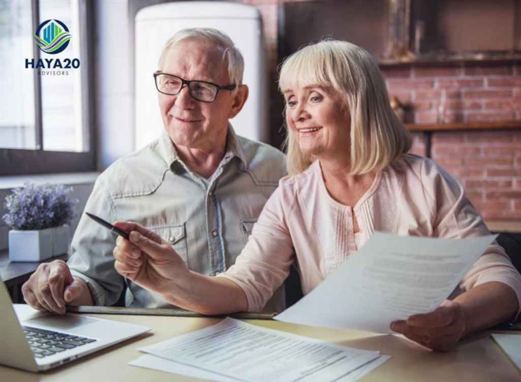 Retired couple reviewing insurance documents and financial plans together at home while planning their retirement coverage.