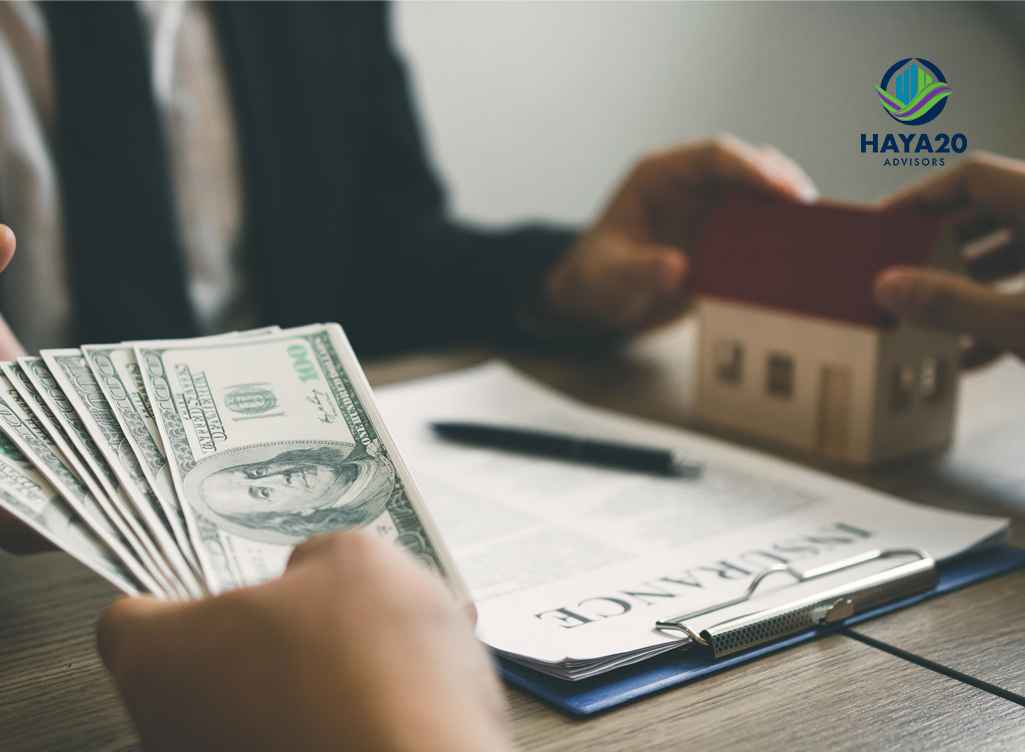 Person counting cash while reviewing real estate investment documents.