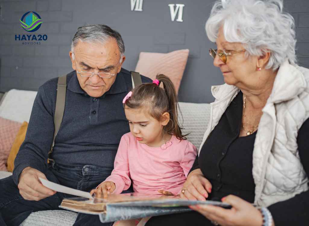 Grandparents reading a book with their young granddaughter at home.