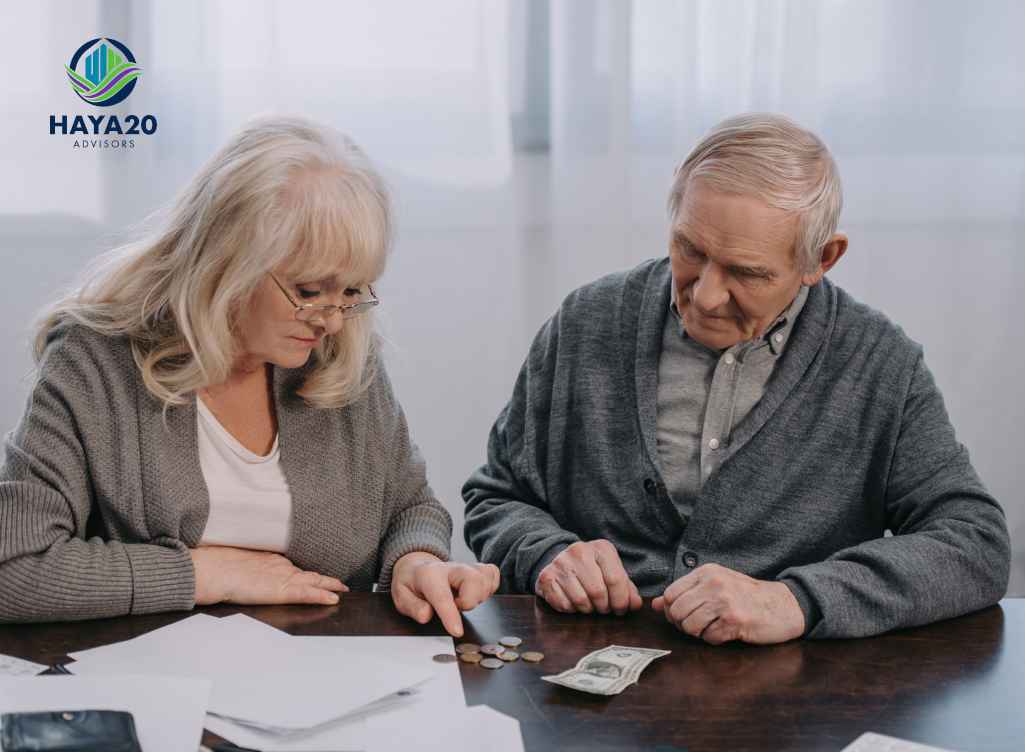 Elderly couple reviewing coins, cash, and financial documents at a table.