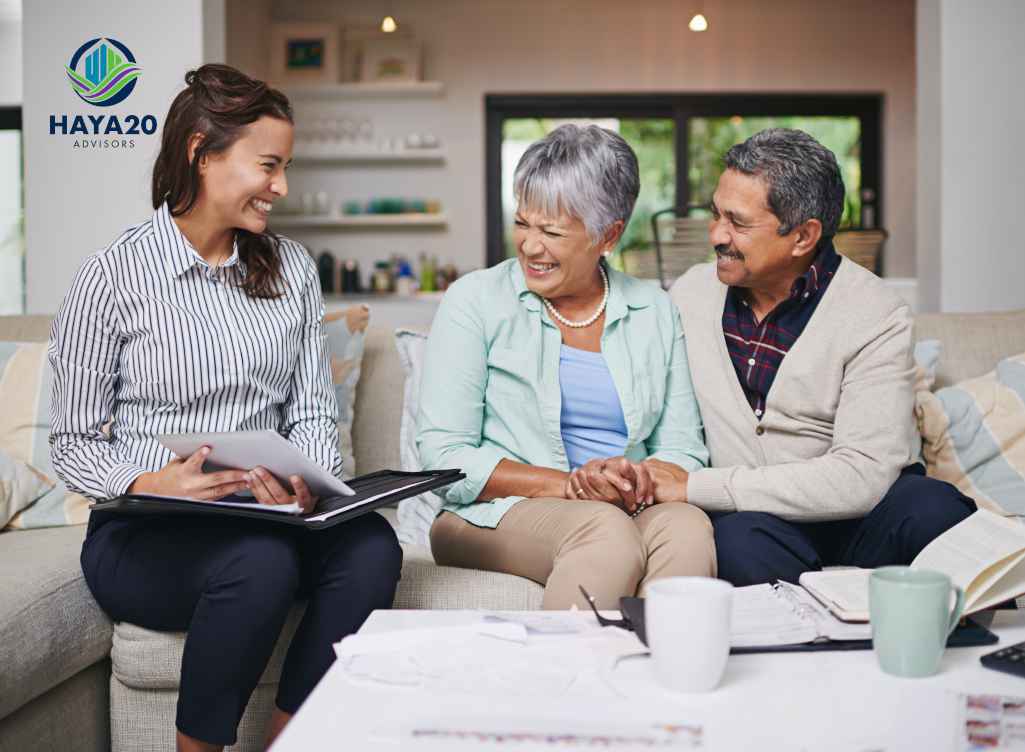 Financial advisor discussing retirement and estate planning documents with an older couple at home.